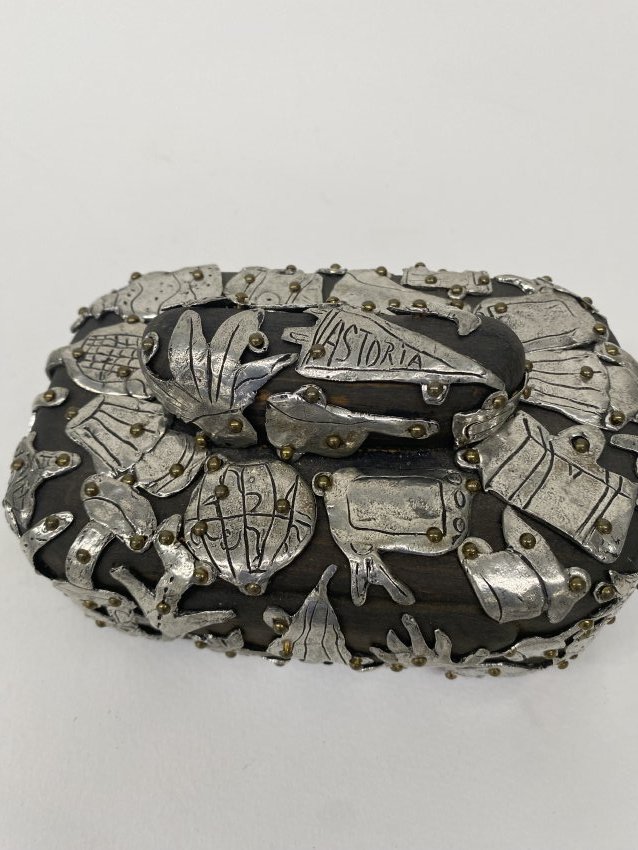 A close of jewelry box with astoria flag and unisphere milagros from the Female Fetish series by Claudia DeMonte