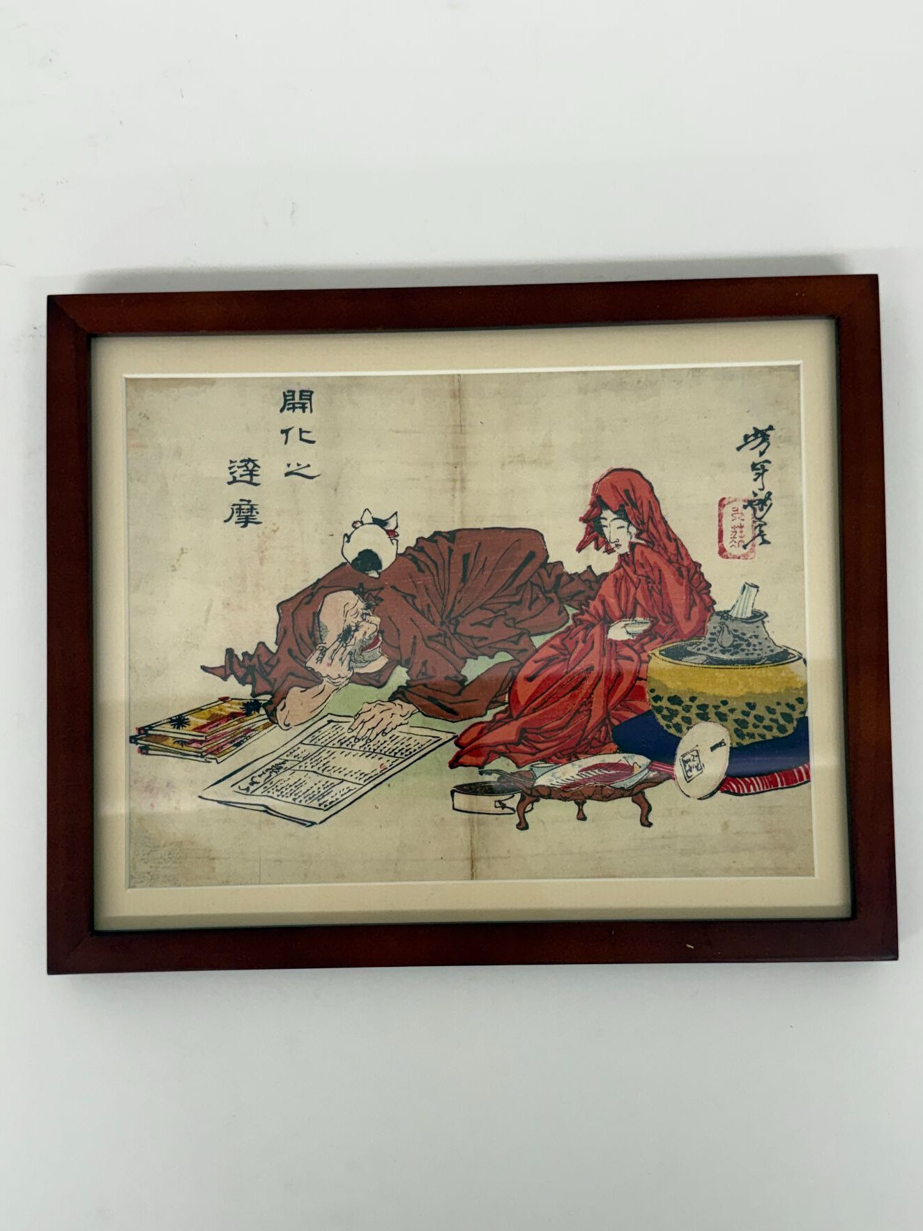 a woodblock print of man on the floor, reading a paper, while conversing with a girl in a red robe